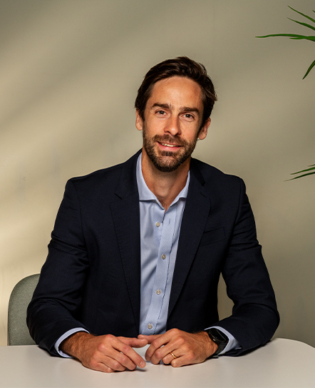Essenta consultant in a dark blazer seated against a light backdrop
