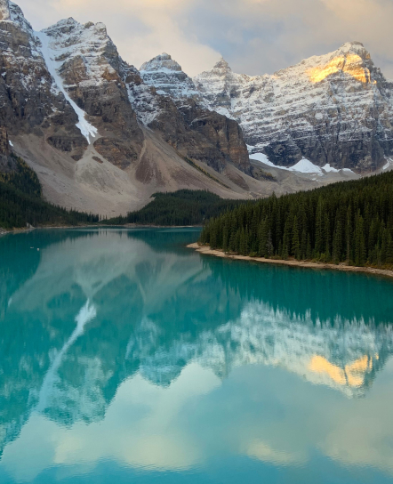 Turquoise mountain lake surrounded by forest and peaks