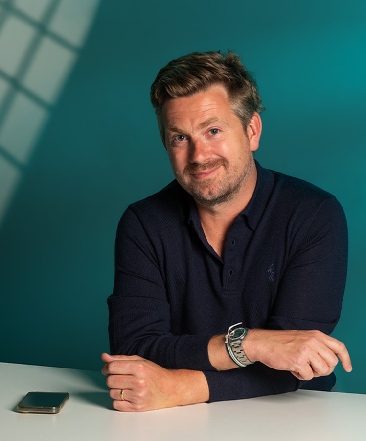 Essenta consultant in a dark jacket against a teal backdrop
